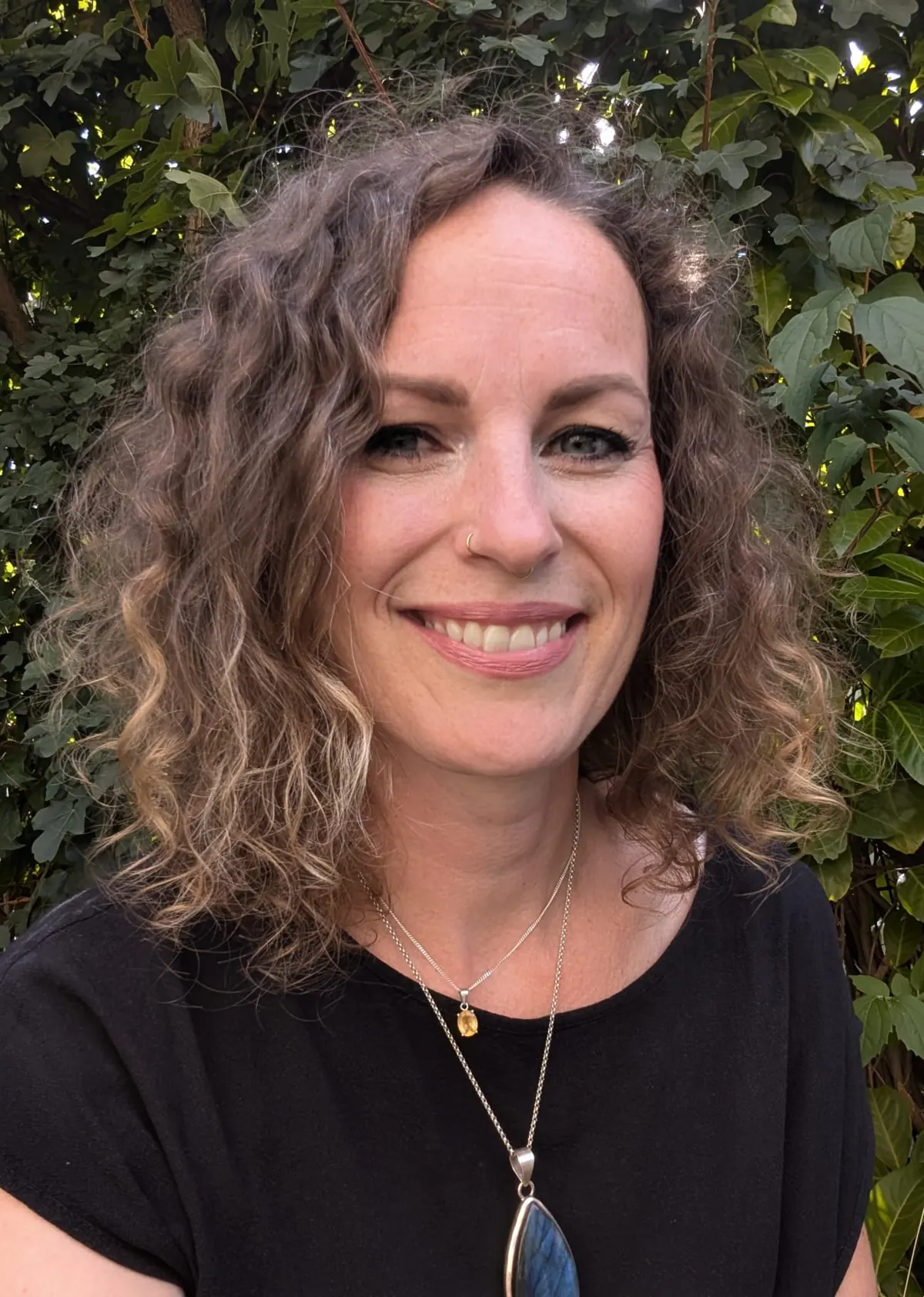 Ivonne Hölzel, Rückführungstherapeutin · Reiki-Meisterin, Porträt vor grünem Laub